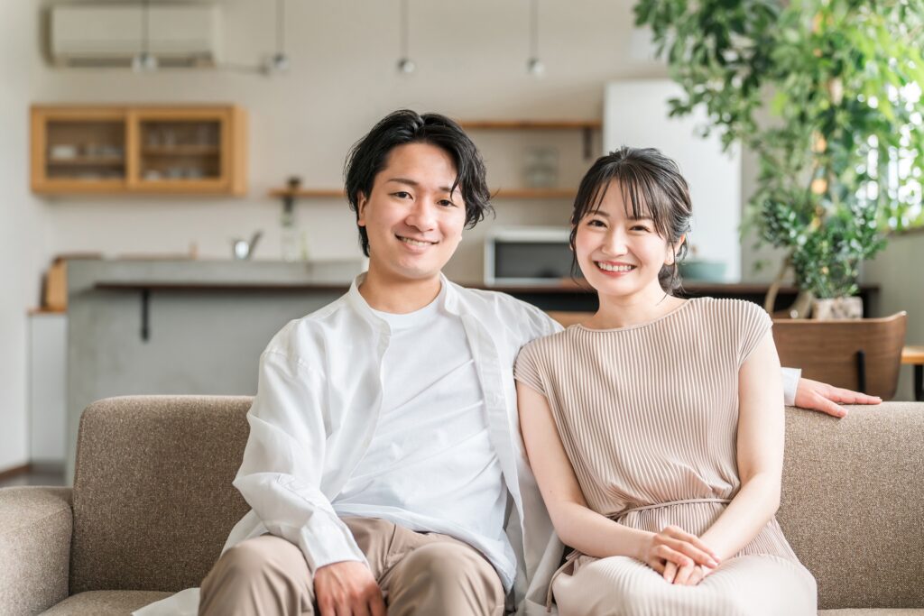 ソファに座って微笑む夫婦