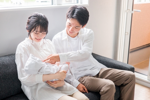 赤ちゃんを笑顔で見つめる夫婦