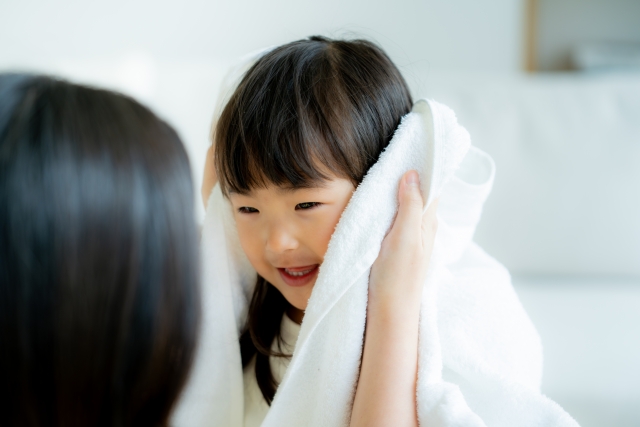 女の子の髪の毛をタオルで乾かしている