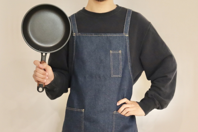 フライパンを持って家事アピールをする男性