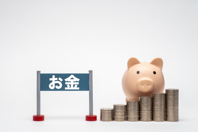 お金段々とが積み重なっている。豚の貯金箱も配置されている。