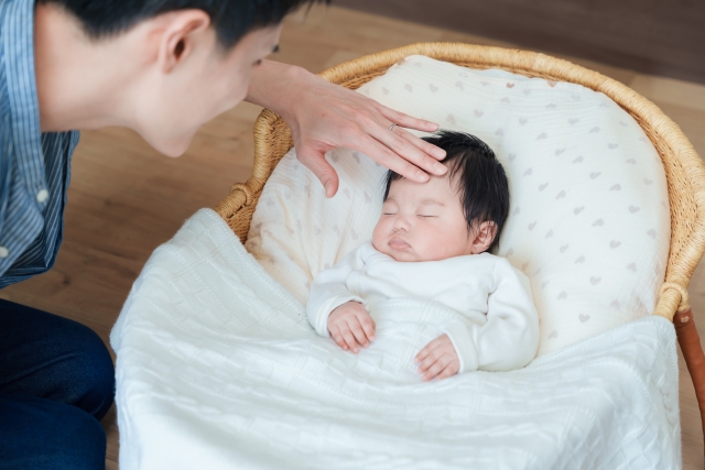 赤ちゃんのおでこを触る父親