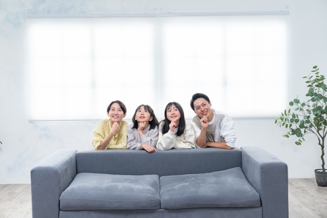 家族が四人でソファに並んでいる画像