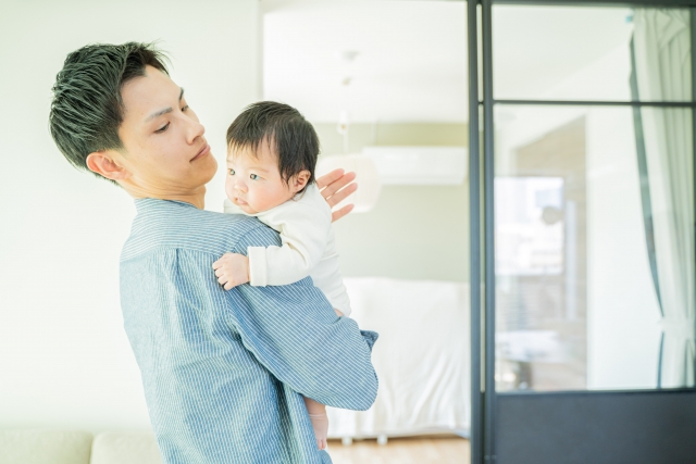 赤ちゃんの背中をトントンと優しく叩くパパ